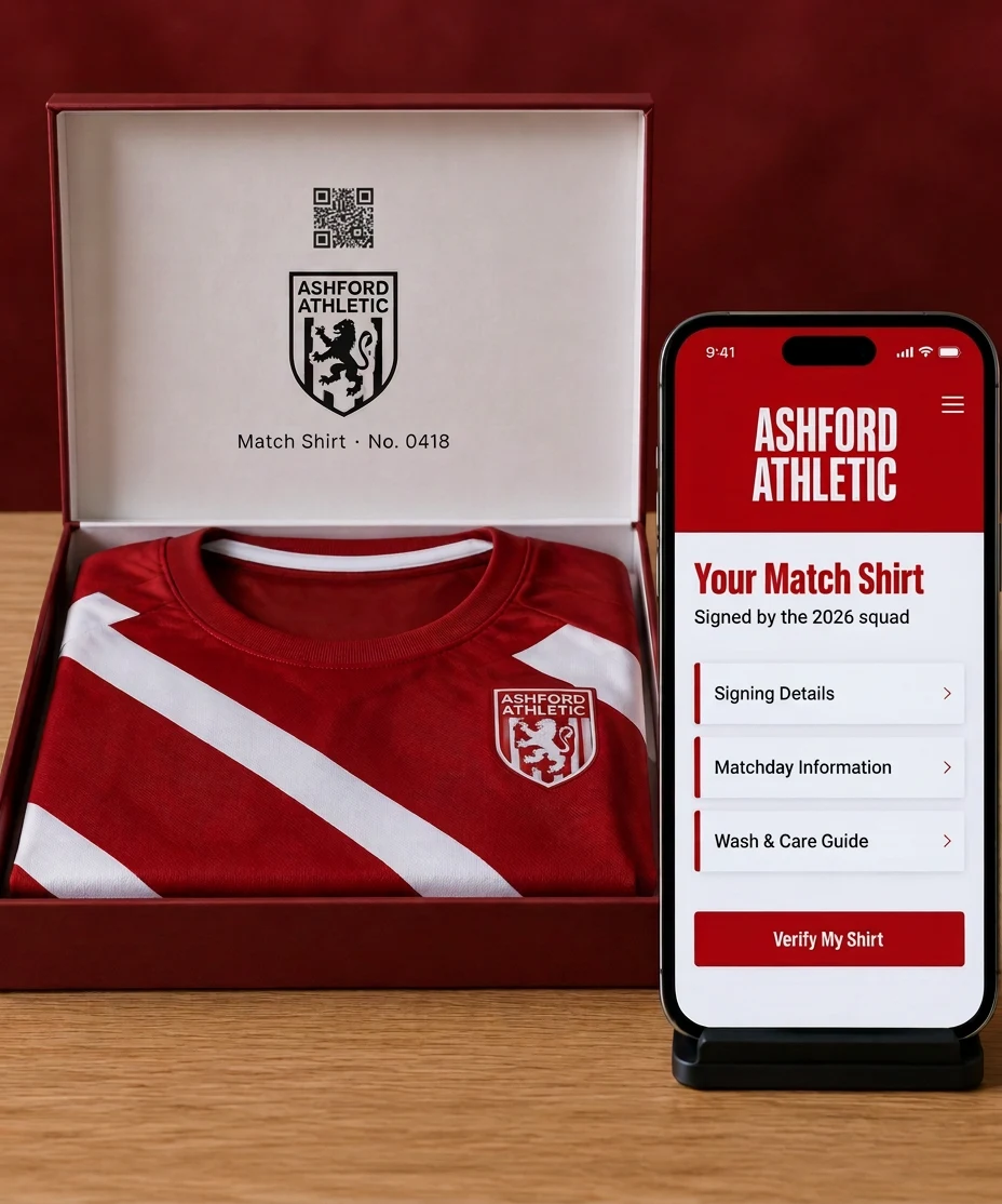 An ASHFORD ATHLETIC match shirt in its box with the code printed inside the lid, beside a phone showing the club's own page